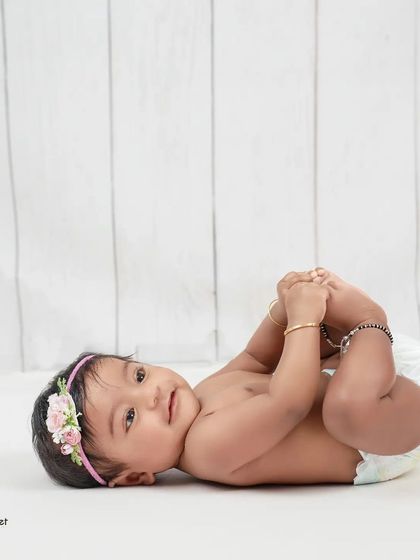 Discovering her tiny toes! We love capturing these simple, authentic moments of discovery during a milestone session. It’s a classic baby pose that never gets old.