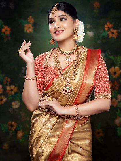 Akanksha looking divine in a red and gold Kanchivaram ensemble. The cut-work blouse, hand-embroidered in zardosi, sequins, and beads, is the highlight of this graceful bridal look.