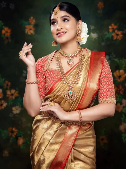 Akanksha looking divine in a red and gold Kanchivaram ensemble. The cut-work blouse, hand-embroidered in zardosi, sequins, and beads, is the highlight of this graceful bridal look.