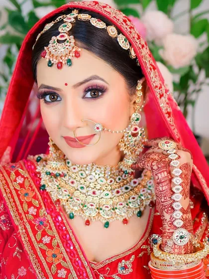 A classic portrait pose, showing the intricate details of the bridal henna and jewelry.