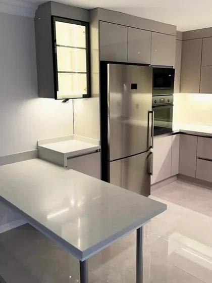This angle shows the practical breakfast counter extension in the DLF Suncity kitchen project. It's a perfect example of how we create multi-functional spaces, combining cooking areas with casual dining.