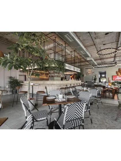 Another view of the versatile seating arrangement, showing how the space can be easily configured. The large tree in the center helps to break up the large room and adds a natural, grounding element.