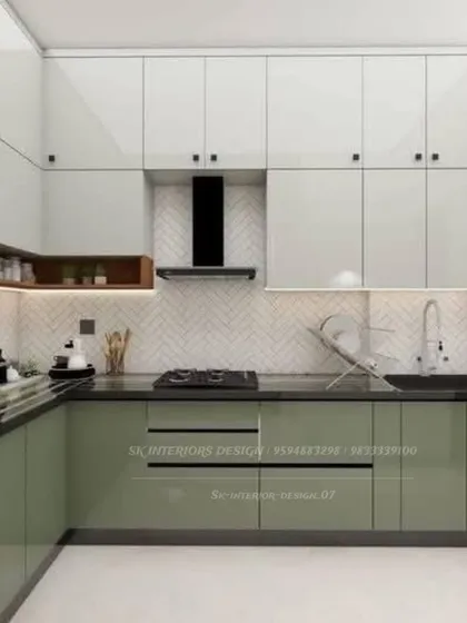 A two-tone kitchen with sage green lower cabinets and white upper cabinets. The herringbone pattern on the backsplash adds a subtle texture to the space.