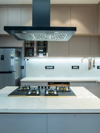 A straight-on view of the kitchen island with its integrated hob. The handleless design keeps the lines clean, and the thoughtful lighting transforms the space from a workspace to an intimate gathering spot.