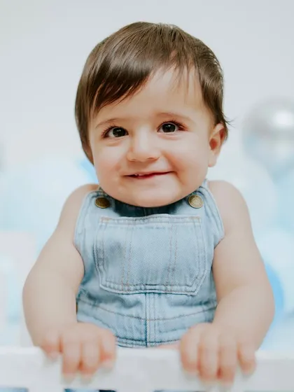 Leaning on the prop bed, this little guy gives a confident smile. This shows how I use simple props to get great poses.