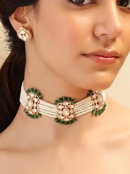 A modern take on the classic choker. This piece features floral motifs crafted from polki and emeralds, strung together with lines of delicate pearls for a fresh and elegant design.