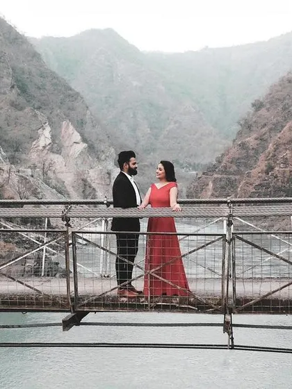 For adventurous couples, a destination pre-wedding shoot is a must. Here, we used the stunning landscape of Rishikesh, with the bridge over the river creating a dramatic and unforgettable backdrop for their love story.