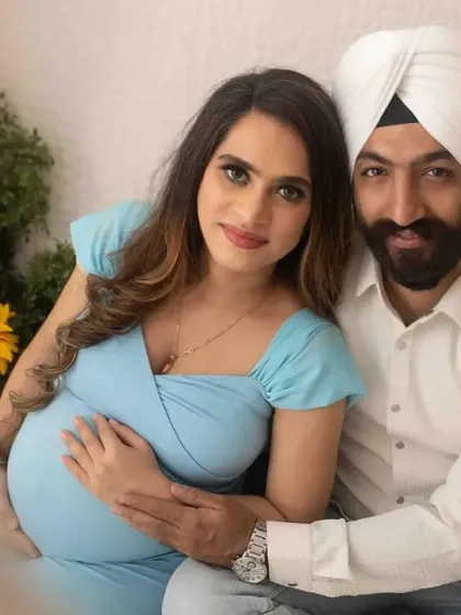 A beautiful couple portrait from a cozy studio setup. They are seated together, with sunflowers adding a cheerful touch, creating a warm and intimate photograph celebrating their journey.