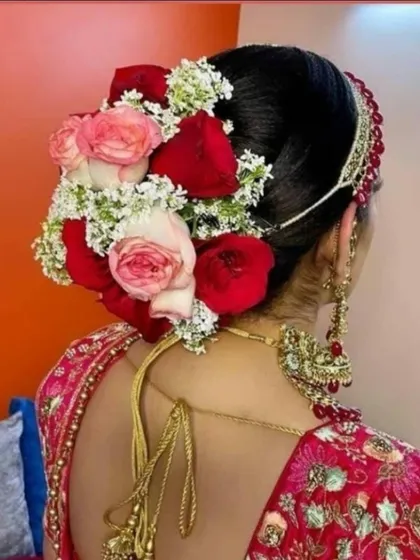 I also create beautiful fresh flower arrangements for the bridal hairstyle. This hair bun is decorated with a mix of pink and red roses, complementing the bride's wedding look.