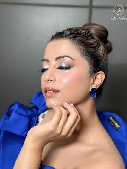 A moment of serene beauty. This pose captures the soft glam makeup, the precise blue liner, and the overall dewy finish.