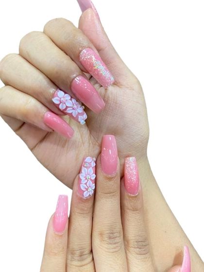 A pretty pink set on long square nails, featuring glitter and 3D floral accents.