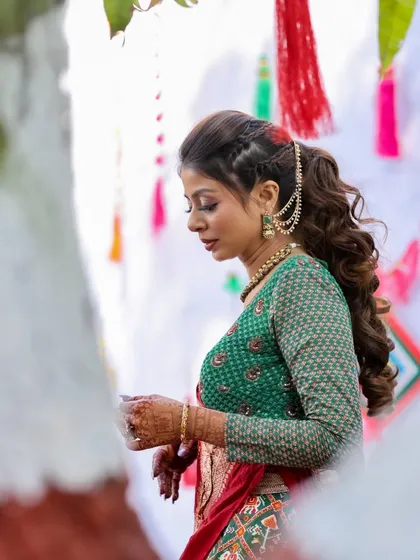 A side profile showing her intricate hairstyle with a traditional accessory, perfect for a wedding ceremony.