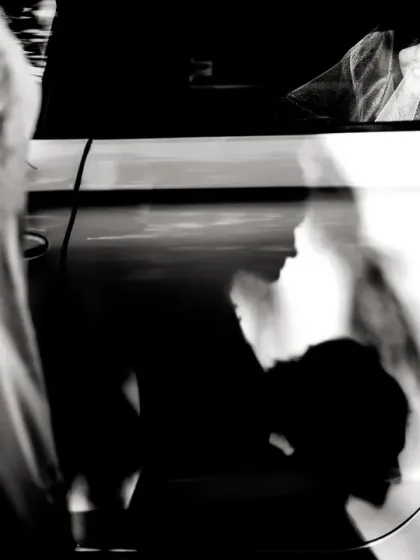 Playing with light and shadow. The bride is visible in the car, but the story is told through the dramatic shadows of people on the car door.