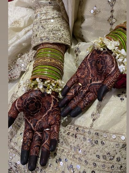 A close-up of a bride's hands, showing the rich stain of her nikah mehendi.