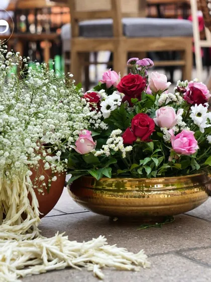 Another view of the decor, showing how we pair traditional elements like brass and terracotta pots with arrangements of baby's breath and roses to celebrate new beginnings.
