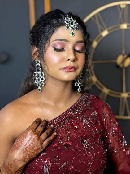 This image showcases a tone-on-tone makeup look for dusky skin. I used warm, earthy shades on the eyes and a glossy nude lip to complement her complexion, paired with elegant green jewellery.