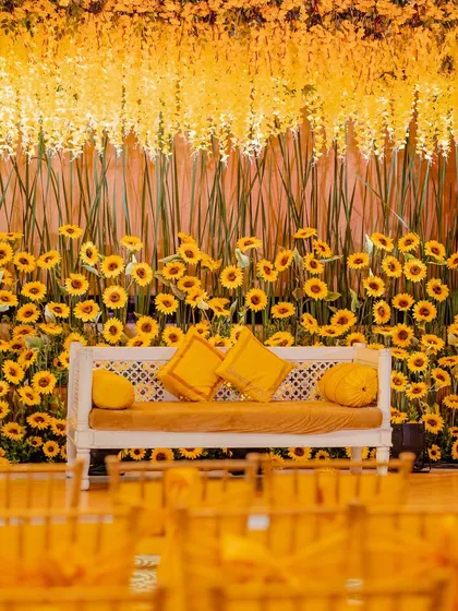 The main seating for the couple at the sunflower Haldi, set against a dense wall of bright yellow sunflowers. This created a stunning and joyful photo backdrop.