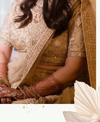 A close-up on the bride's hands, showcasing her intricate henna design and beautiful wedding jewelry.