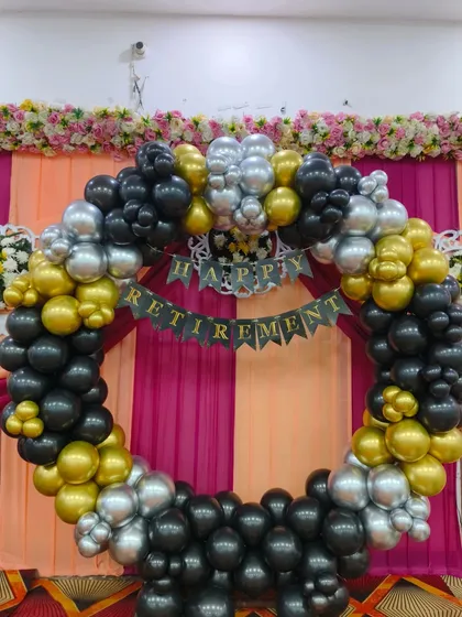I design elegant decorations for important life milestones like retirement. This party backdrop features a full circle of black, gold, and silver balloons with a "Happy Retirement" banner. This classic color combination provides a festive yet sophisticated look for the occasion.