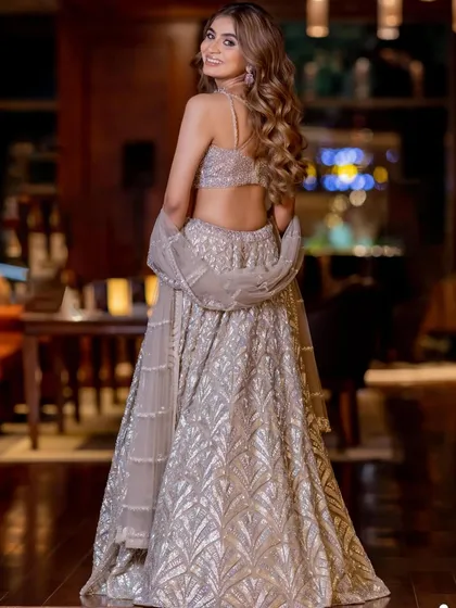 A back view that shows off her gorgeous hair and the stunning design of her lehenga, ready for a night of dancing.