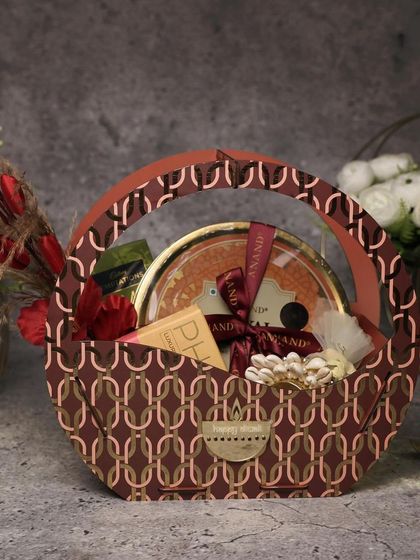 This stylish, budget-friendly Diwali hamper is perfect for corporate gifting. The patterned paper basket is filled with treats and comes with a "Happy Diwali" card, offering a classy yet affordable option.