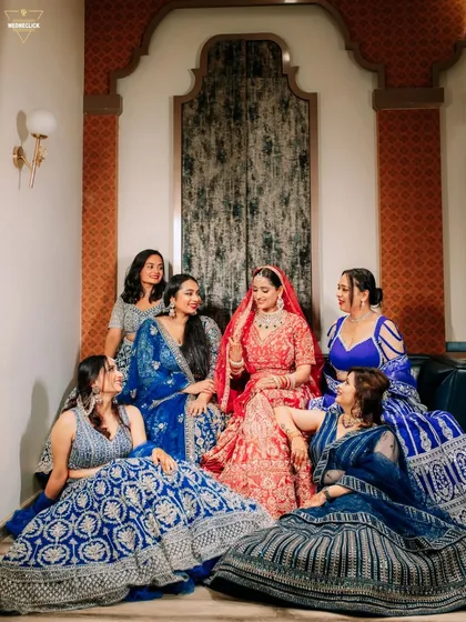 A lovely portrait of the bride seated with her bridesmaids, all dressed in beautiful shades of blue, creating a perfect picture of friendship.