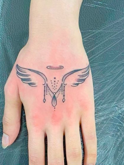 An ornamental angel wings design on the back of the hand.