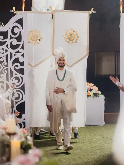 The groom's grand entrance. We use props like these elegant banners held by dancers to create a royal procession feel as he walks in.