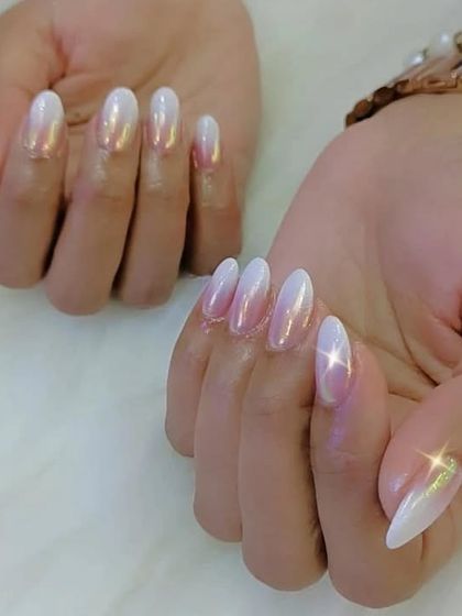 A beautiful set of almond-shaped nails with a pearly, iridescent white chrome finish that shines beautifully.