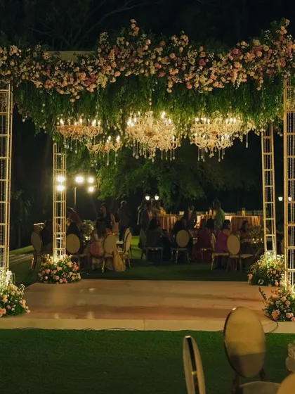 The evening reception setup, where the daytime mandap was transformed into a dance floor under a canopy of flowers and chandeliers.