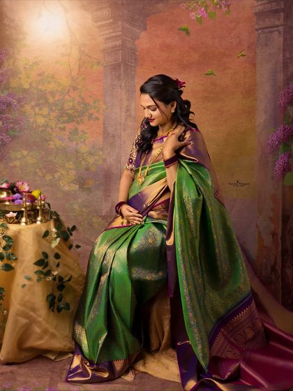 A serene and contemplative portrait of a mother-to-be. Seated in a beautiful paithani saree, she gently holds her baby bump in a moment of quiet connection.