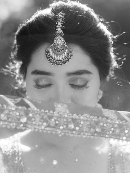 A delicate black and white portrait of a bride, her eyes closed, a moment of serene beauty.