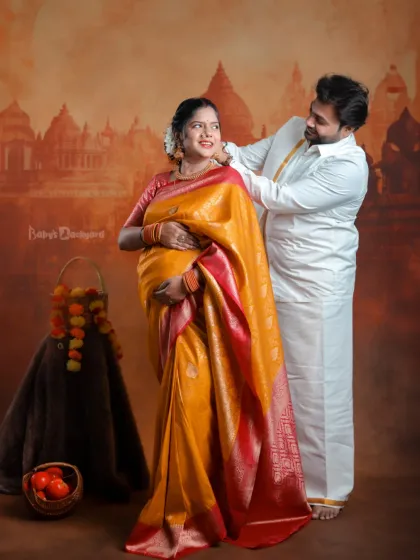 We celebrate your journey into parenthood by weaving in the beauty of your traditions. This couple's portrait, set against a classic backdrop, captures the warmth and richness of a South Indian maternity celebration.
