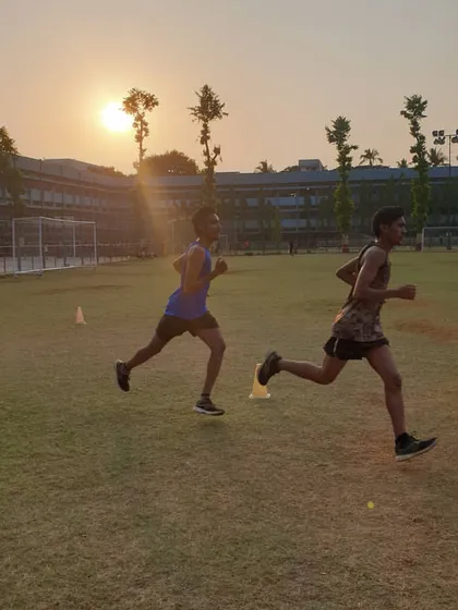 Two athletes execute a running drill at sunset. We emphasize proper running form and pacing to build endurance and speed, creating an environment where every athlete can push their personal boundaries.