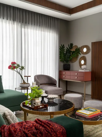 A detail shot of the lounge, showcasing the mix of materials: velvet, marble-topped tables, and a terracotta-colored console. This layering of textures and colors adds depth and interest to the space.