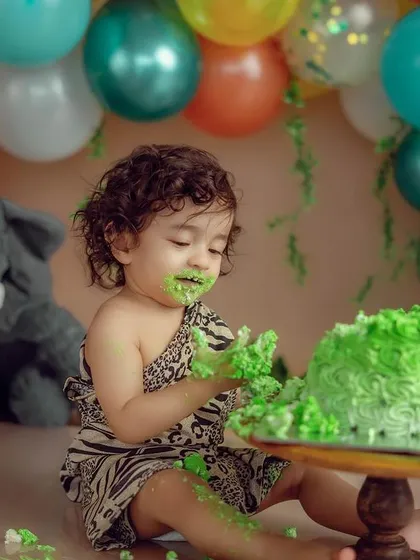 A classic cake smash moment. I love capturing the delightful mess and curiosity as a baby explores their first birthday cake in a fun, jungle-themed setup.