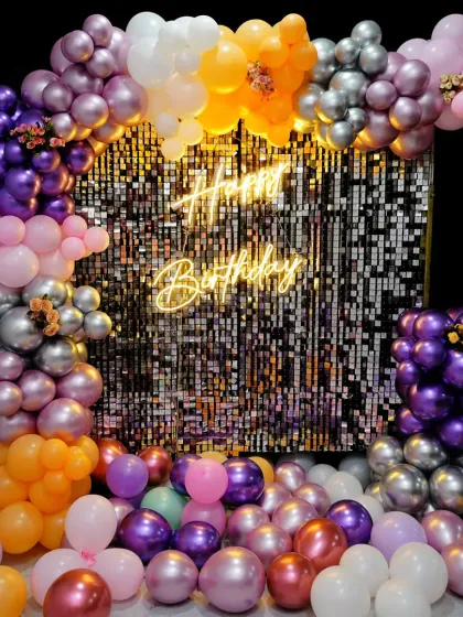 I love using sequin walls to add a touch of glamour. This setup features a shimmering silver sequin backdrop framed by a vibrant balloon arrangement and a bright neon sign, perfect for milestone birthdays, bachelorettes, or any glam party.