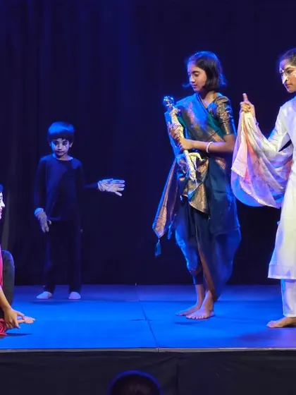 A scene from a children's play where young actors confidently perform for a captivated audience.