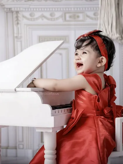 A moment of pure joy at the piano. We capture the delightful expressions as children explore the mini grand piano prop in our music-themed shoot.
