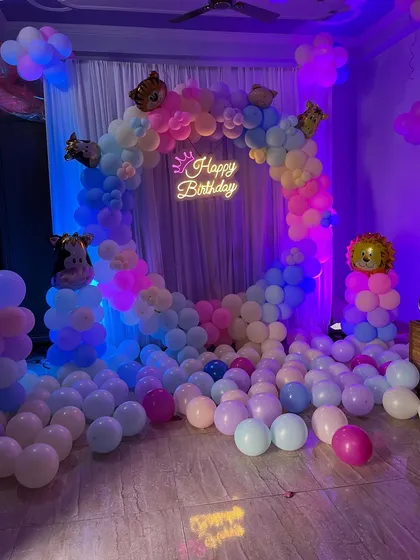 The main backdrop for the pastel animal party, with balloons scattered on the floor.