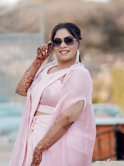 A close-up of the bride, showing off her modern Haldi look with sunglasses and intricate mehendi.