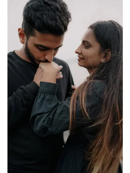 A classic, chivalrous gesture of him kissing her hand. This close-up is incredibly romantic and timeless, focusing on a small act of love.