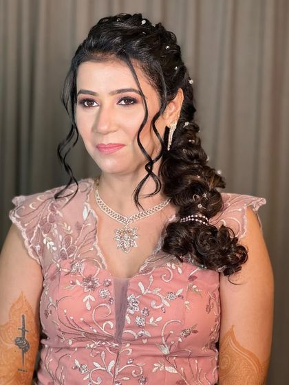 This bride looks absolutely radiant with her crystal-studded side braid, a perfect hairstyle for dancing the night away at her Sangeet.