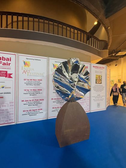 Another view of "Eclipse" at the art fair, a piece that contrasts raw, weathered steel with a highly polished, modern form.