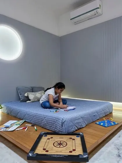 A fun and functional room designed for a child. The platform bed provides space for play, while the circular backlit wall niche and pink wardrobe add a touch of whimsy.
