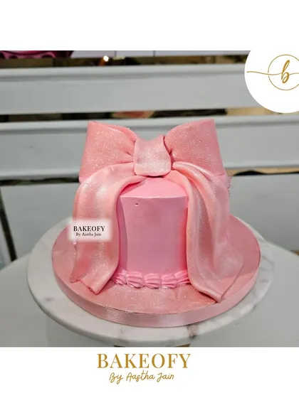 Indulge in elegance with this stunning pink bow cake. The velvet-textured fondant bow makes a beautiful statement on this simple, chic cake.