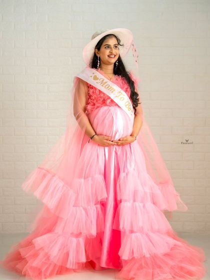 Ready for a baby shower celebration, this client pairs the pink ruffled gown with a "Mom to Be" sash and a stylish hat.
