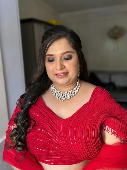 A classic party look with a soft brown smokey eye and a neutral lip. This allows her beautiful red outfit and diamond necklace to take center stage.