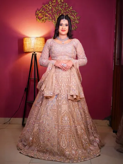 This beige and silver lehenga offers a sophisticated and understated elegance. The peplum-style blouse adds a modern structural element.