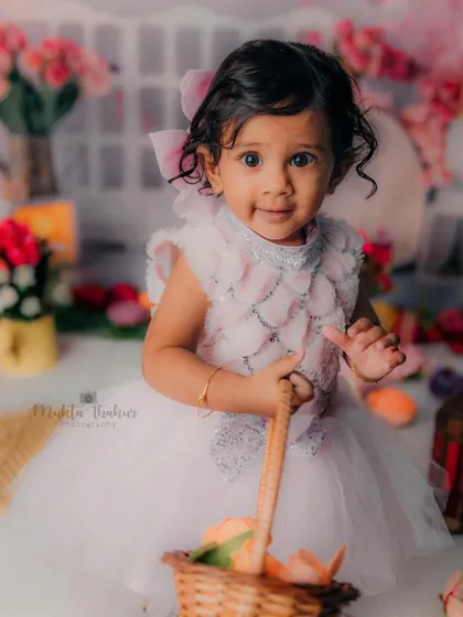 This little one is ready for a garden party. The basket of flowers and her sweet smile make for a perfect first birthday portrait.